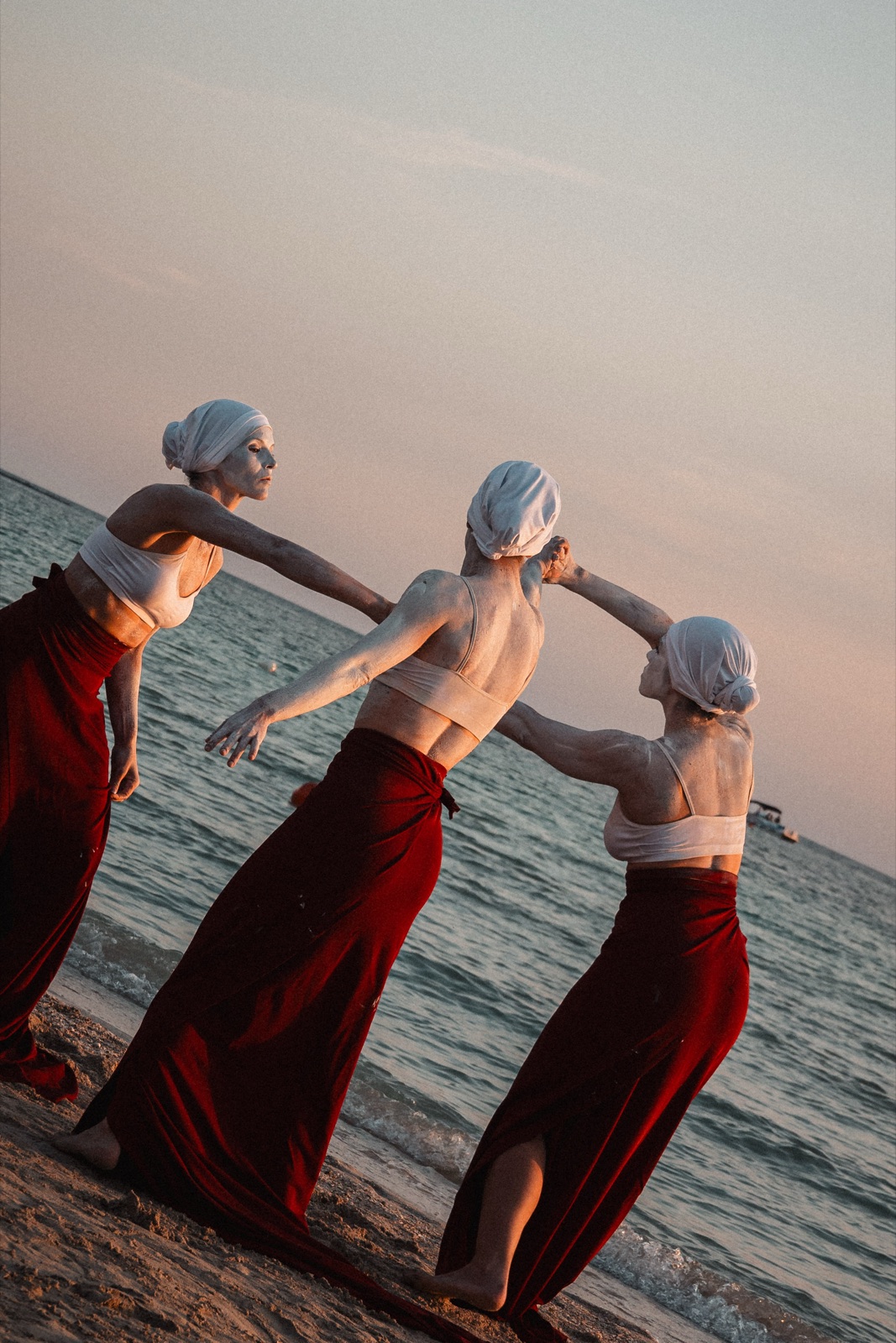 tre danzatrici in diagonale sulla spiaggia