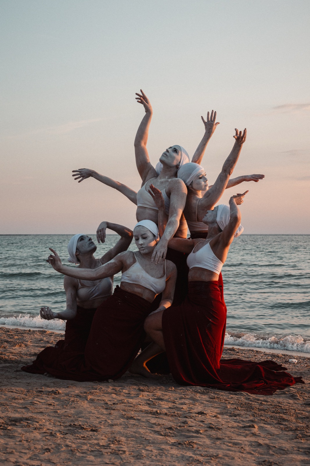 gruppo di danzatrici in posa scultorea con il mare