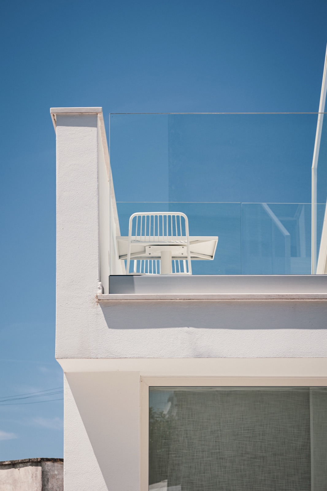 villa bianca con balcone in vetro e cielo blu