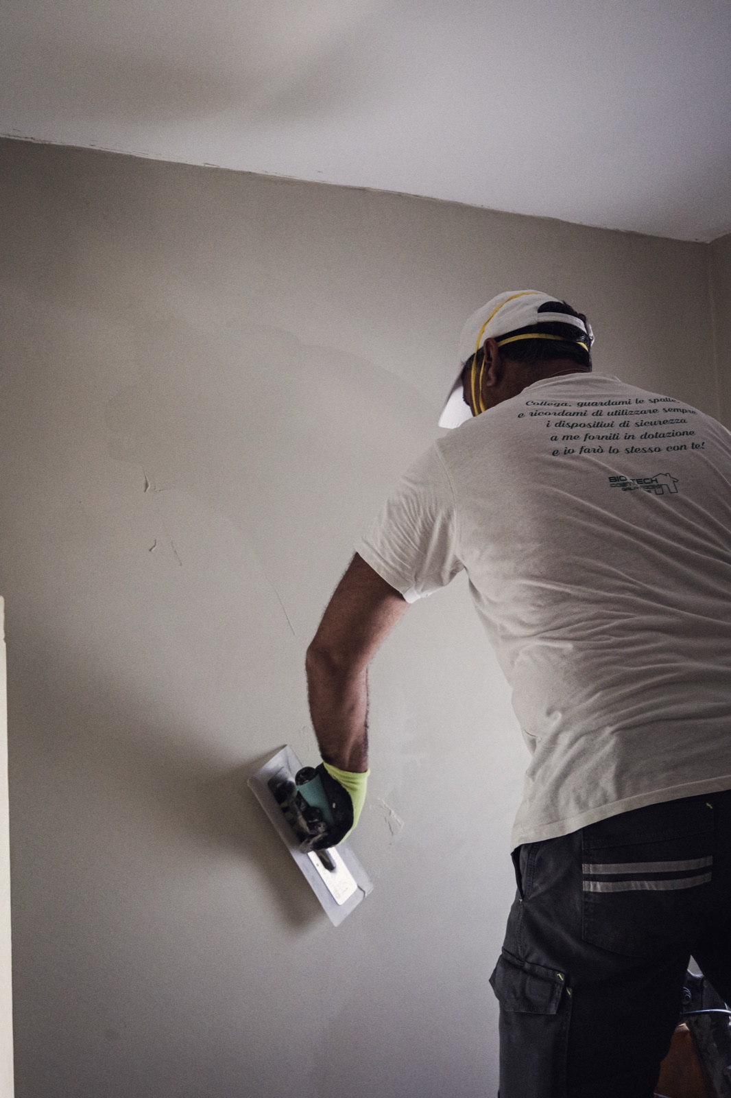 intonacatore con il casco al muro, verticale