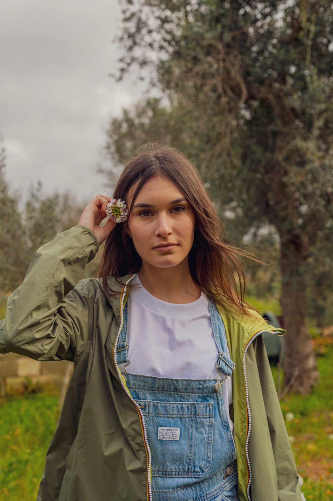 donna salopette denim e K-Way verde, ritratto