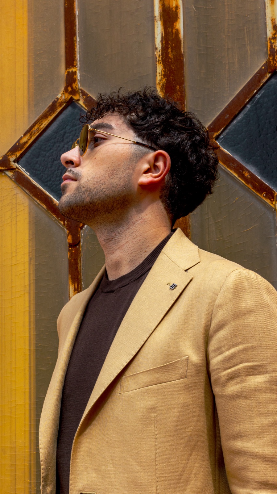uomo in lino beige, profilo su vetrata