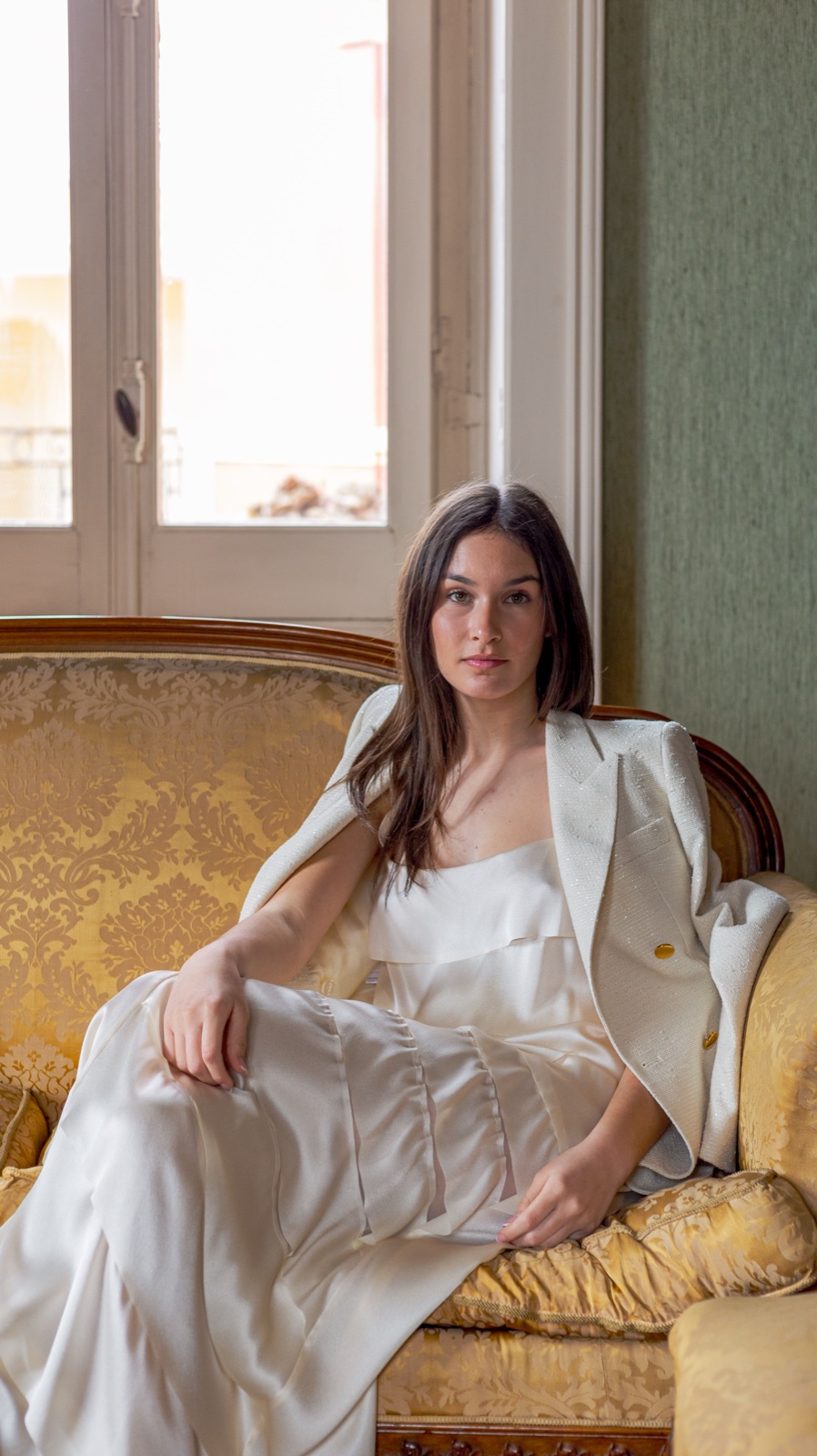 donna in bianco su divano dorato