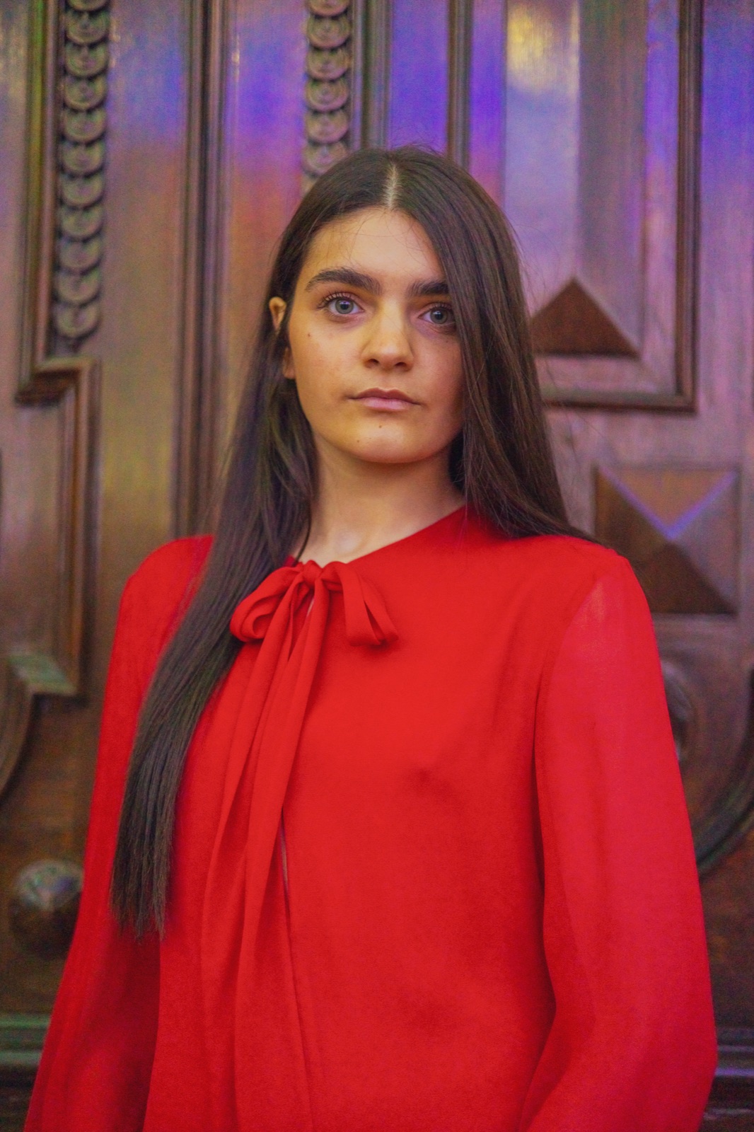 abito rosso con pochette oro, ritratto sotto le luminarie