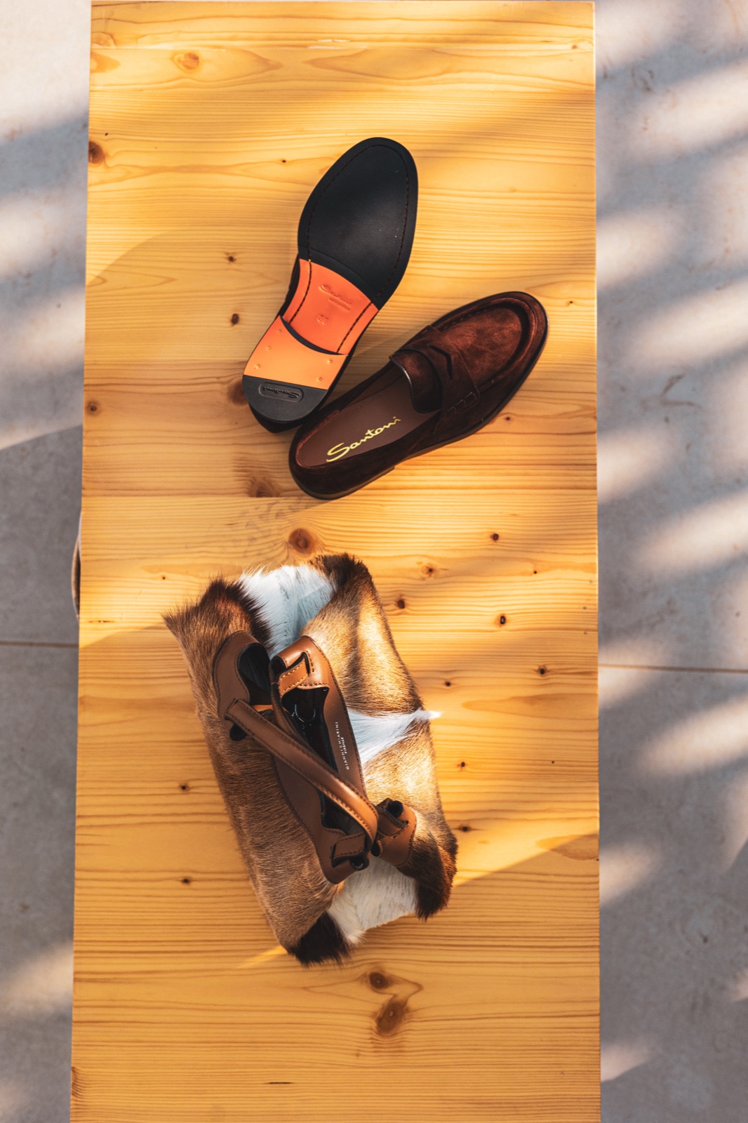 mocassini Santoni sul legno con ombre dure