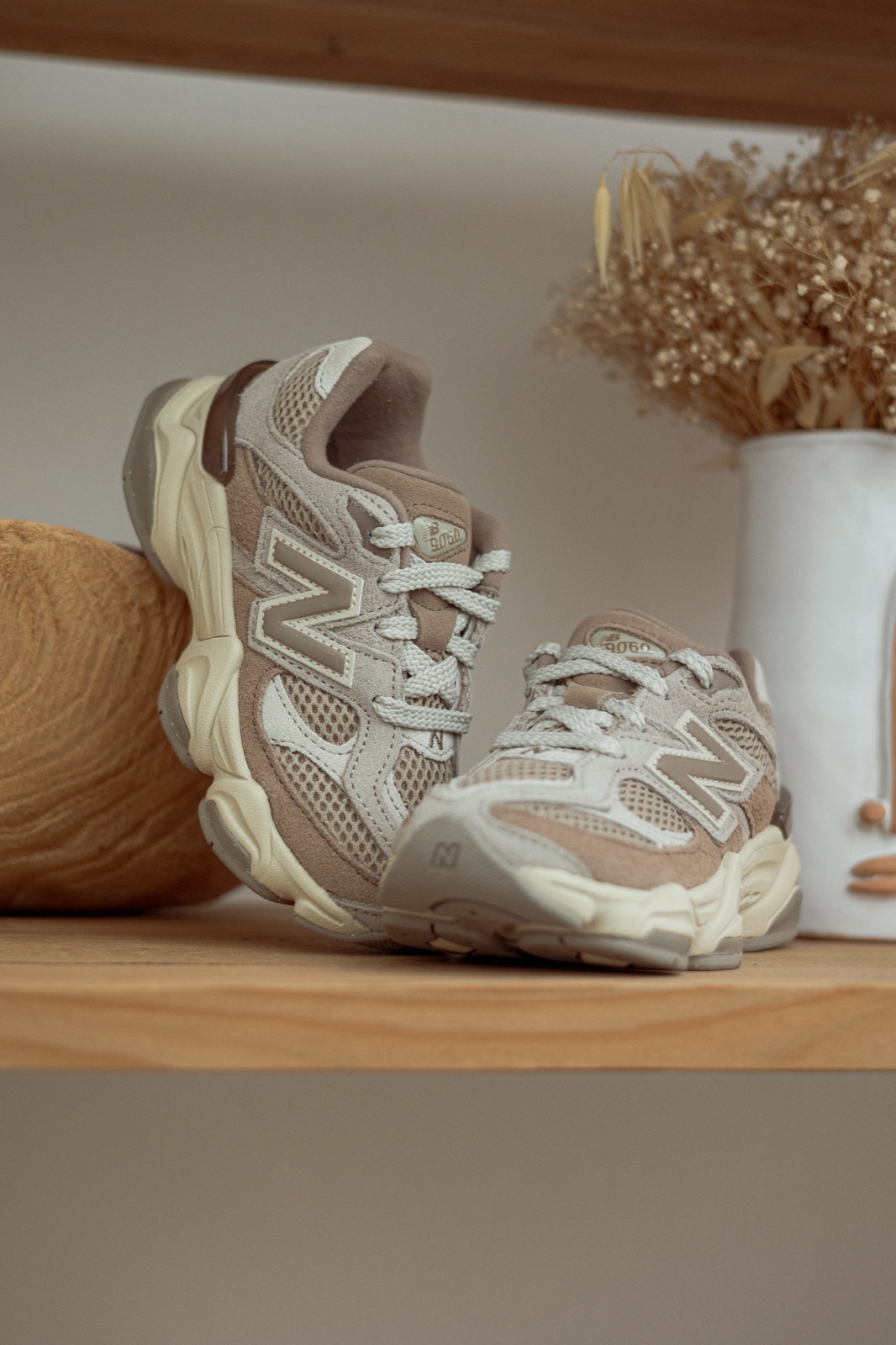 sneaker sulla mensola di legno con fiori secchi