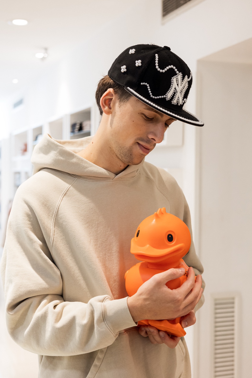 ragazzo con cappellino e papera Save the Duck in negozio
