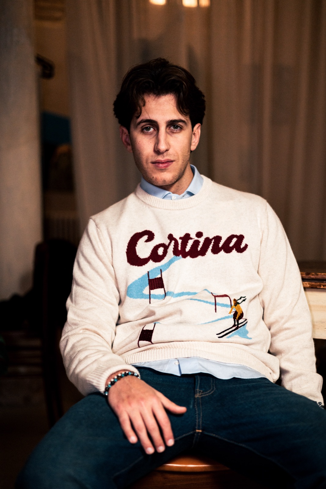 uomo seduto con maglione Cortina panna