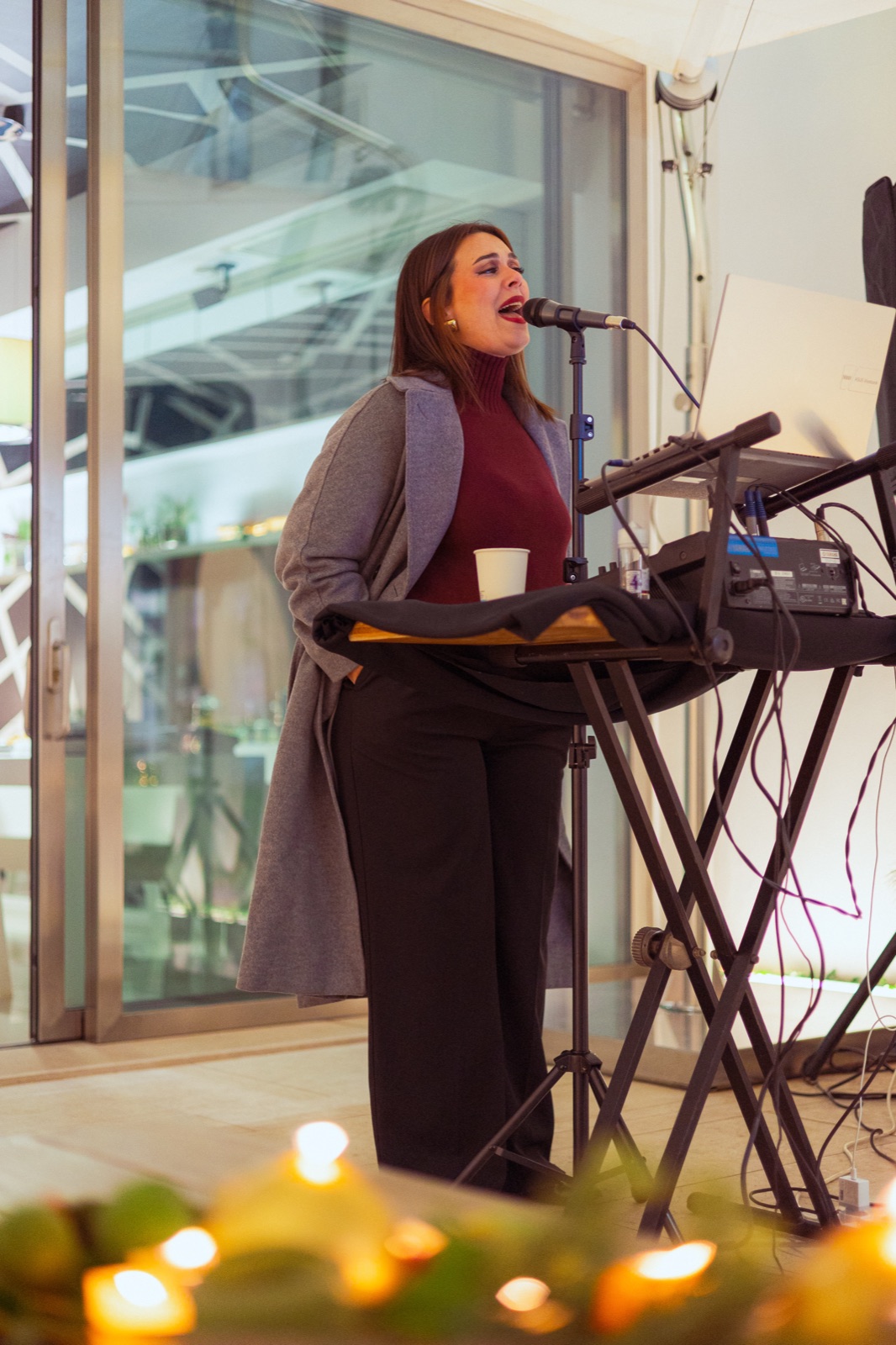 cantante con tastiera in negozio, candele in primo piano (evento vigilia)