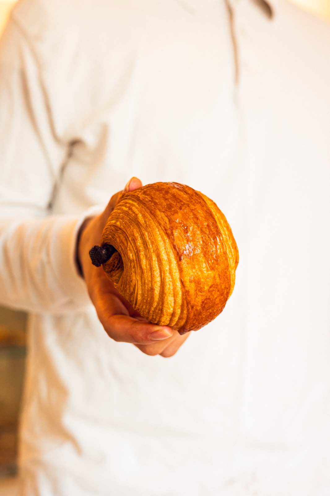fornaio che porge il pain au chocolat