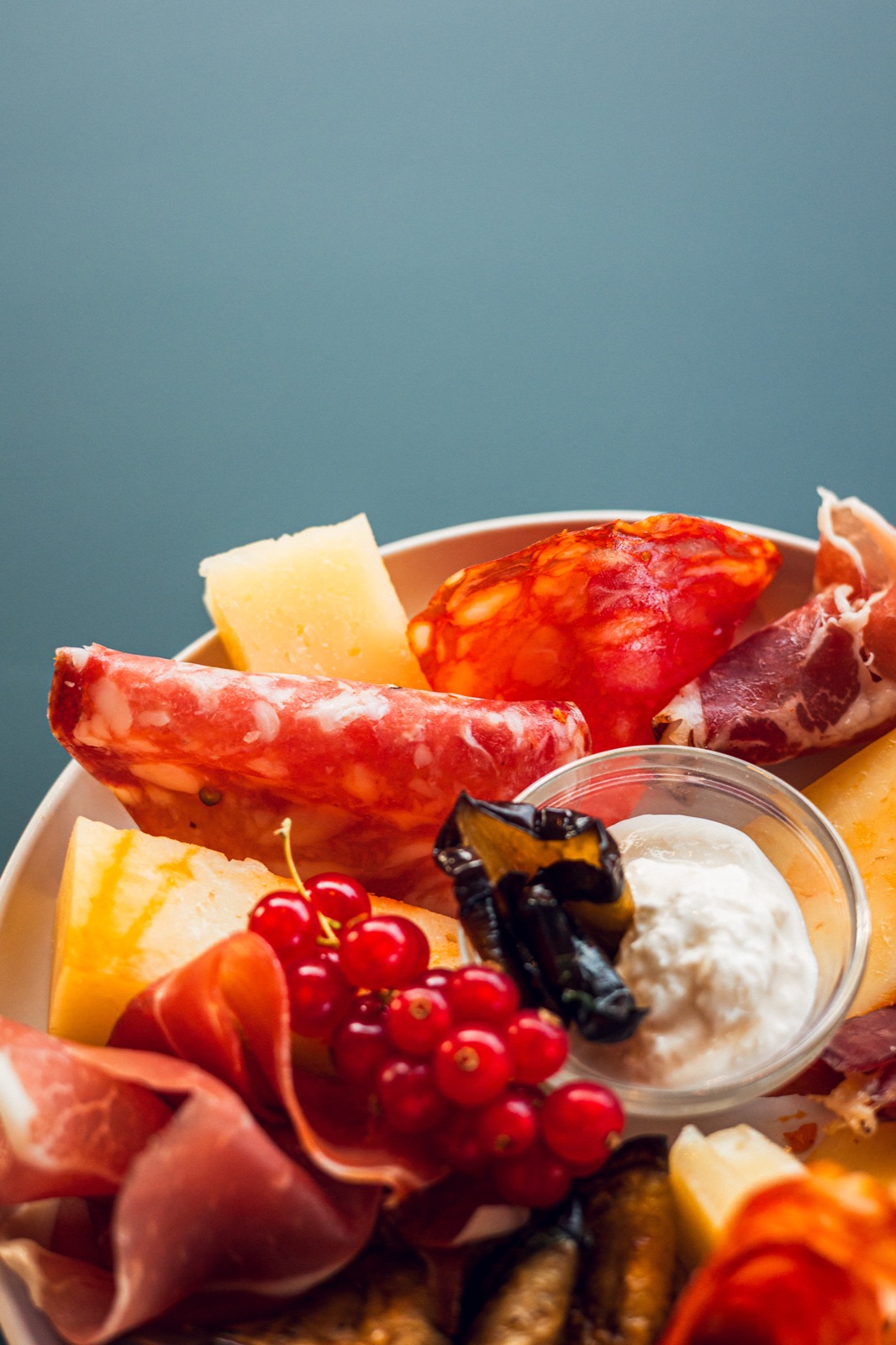 tagliere di salumi e formaggi su fondo blu