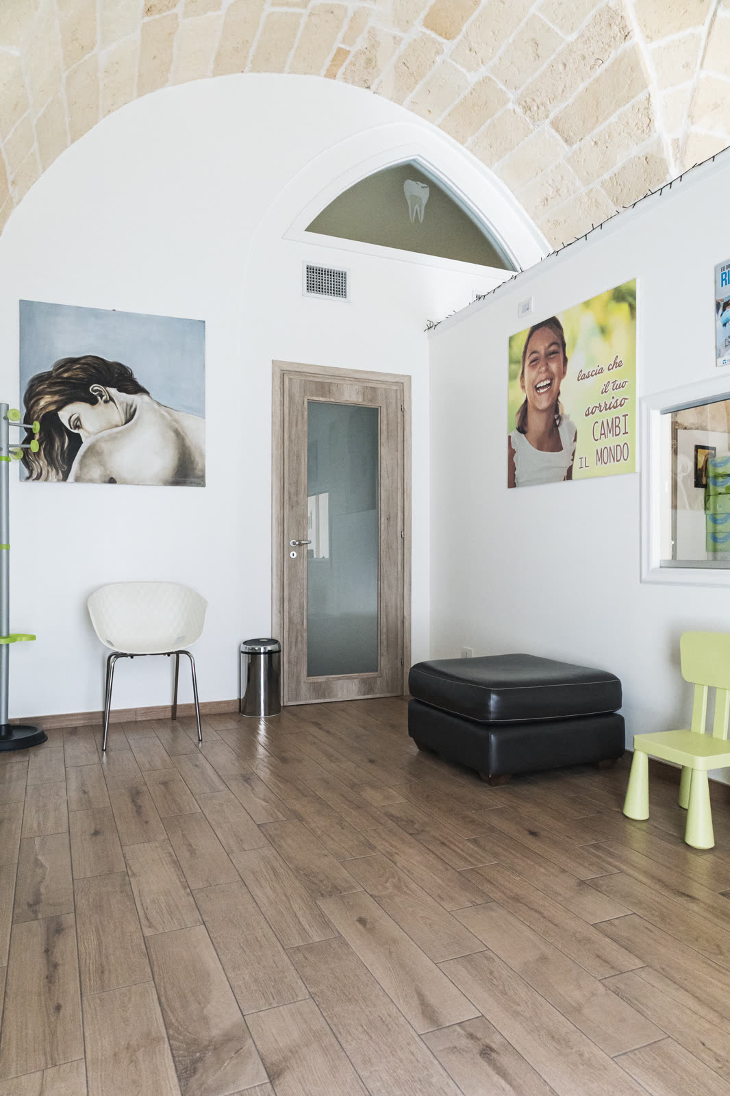 sala d'attesa con l'arco, il pavimento in legno e la seggiolina per i bambini